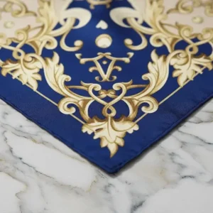 Detail of a baroque silk scarf on a white marble background